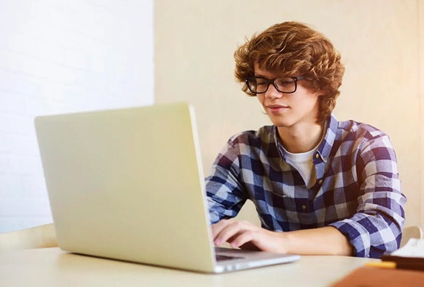 Student typing on a laptop at a desk.