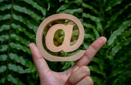 at symbol against background of green leaves